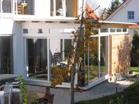 Einfamilienhaus Marzling Blick vom Garten auf die Fassade mit erdgeschossigem Anbau